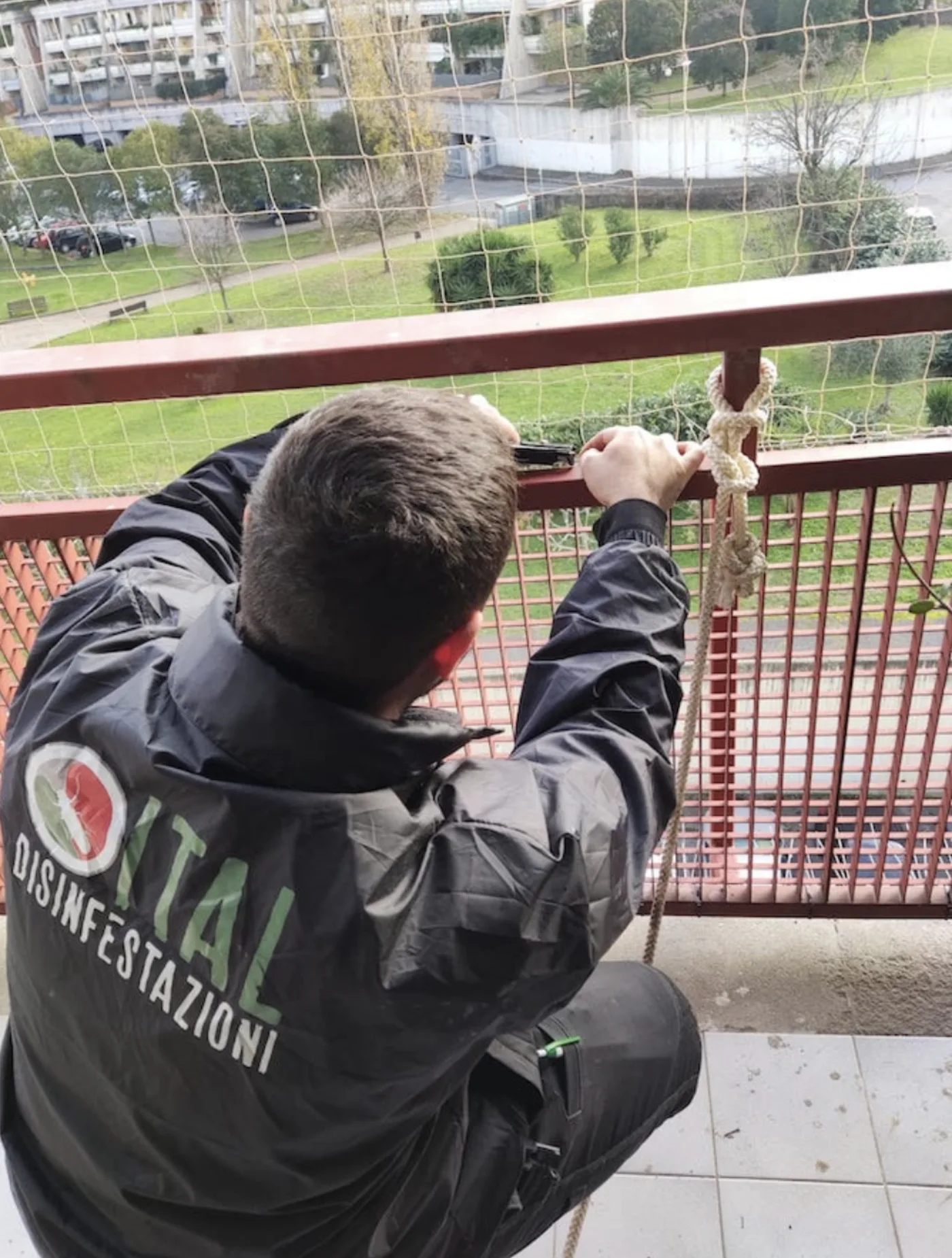 Tecnico Ital Disinfestazioni installa rete antipiccione su balcone condominiale a Torino